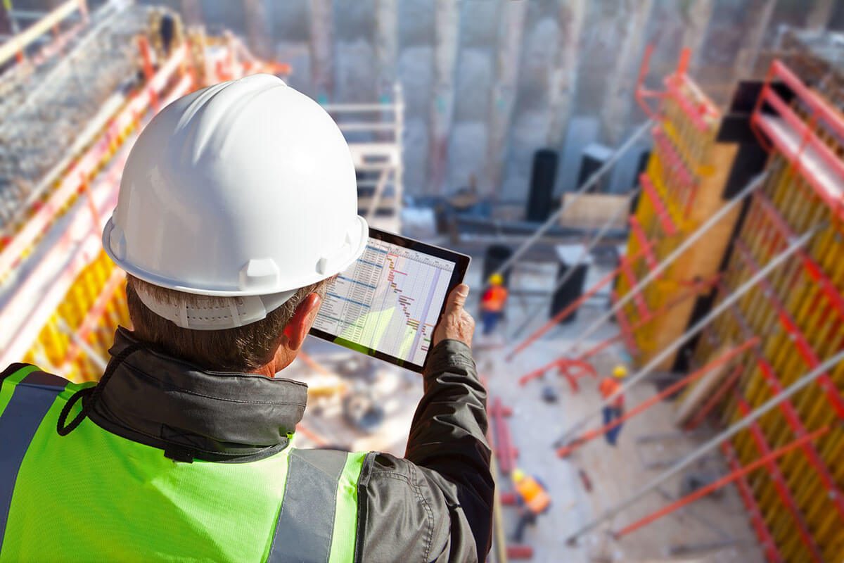 Site manager reviewing project data on a tablet at a construction site